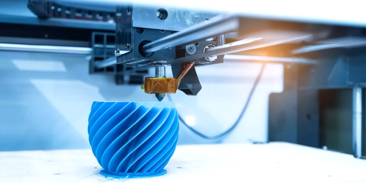 Finished 3D-printed parts in white and gray arranged on a bright workbench